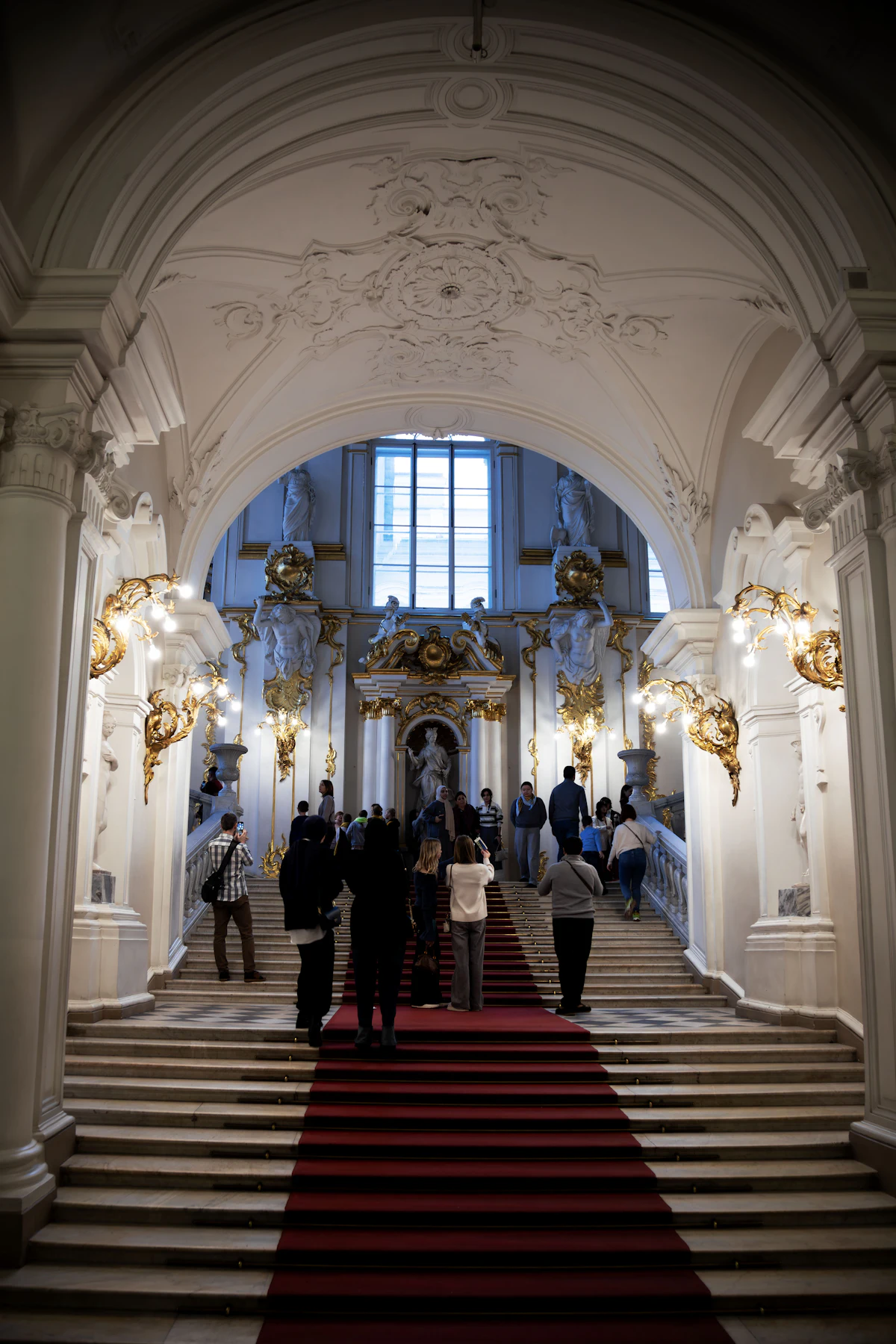 Guests walking up a grand staircase with a red carpet